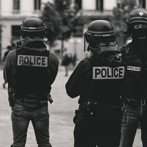 Photos en noir et blanc de 3 policiers avec des casques